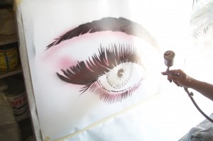 Artist, Lynn Burton, working on airbrush painting. 